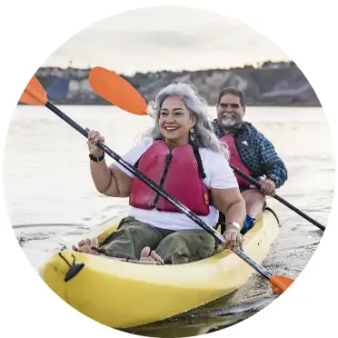 a couple in a yellow kayak with orange paddles