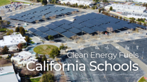 An aerial view of Mission College in Santa Clara, California, showcasing a large solar carport installation across a parking lot, with trees and campus buildings in the foreground. The text overlay reads "Clean Energy Fuels California Schools" with a note below stating "Mission College | Santa Clara, California | PV 2.1 MW | BESS 1MW ". The image highlights the integration of renewable energy infrastructure at educational institutions.